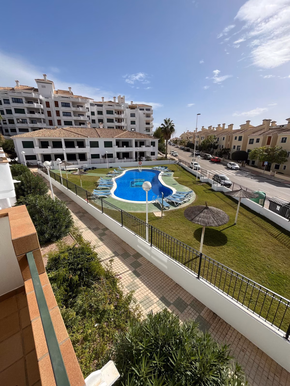 Widok z tarasu na basen i ogrody Residencial Iron