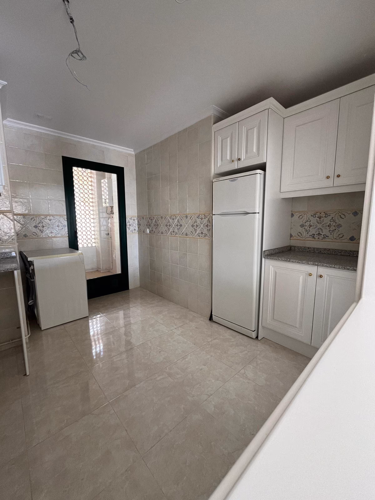 Kuchnia z lodówką i drzwiami do pralni w Residencial Iron