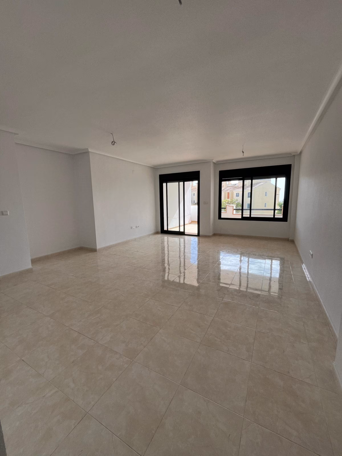 Pusty salon z dwoma oknami w Residencial Iron