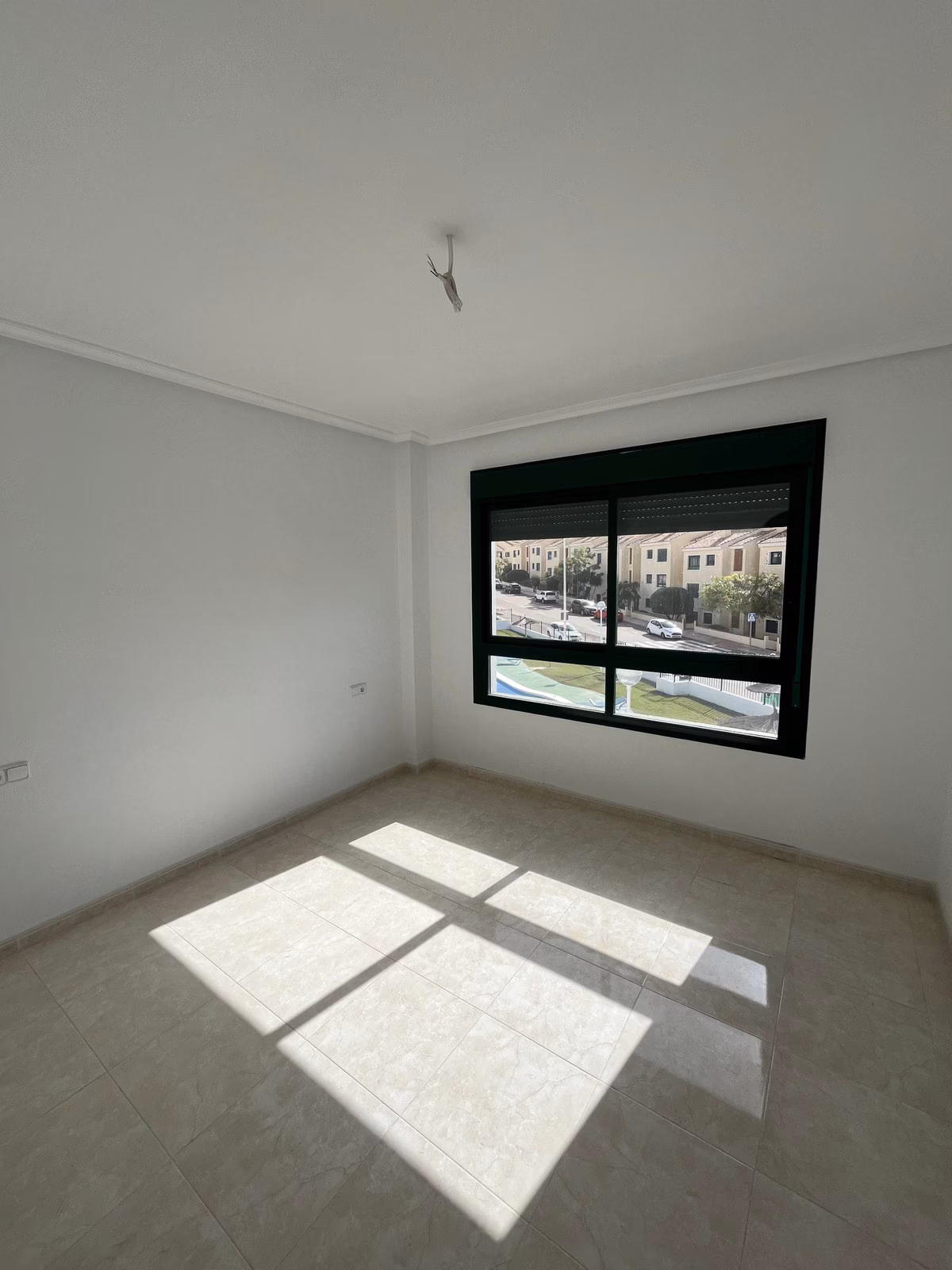 Sypialnia z oknem w ciemnej ramie w Residencial Iron
