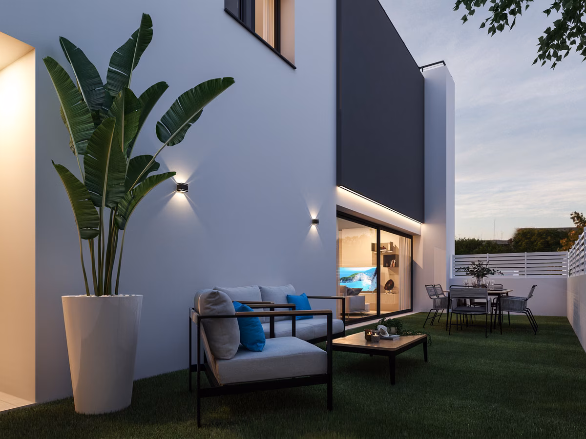 Terrasse mit Outdoor-Sofa am Haus in der Abenddämmerung