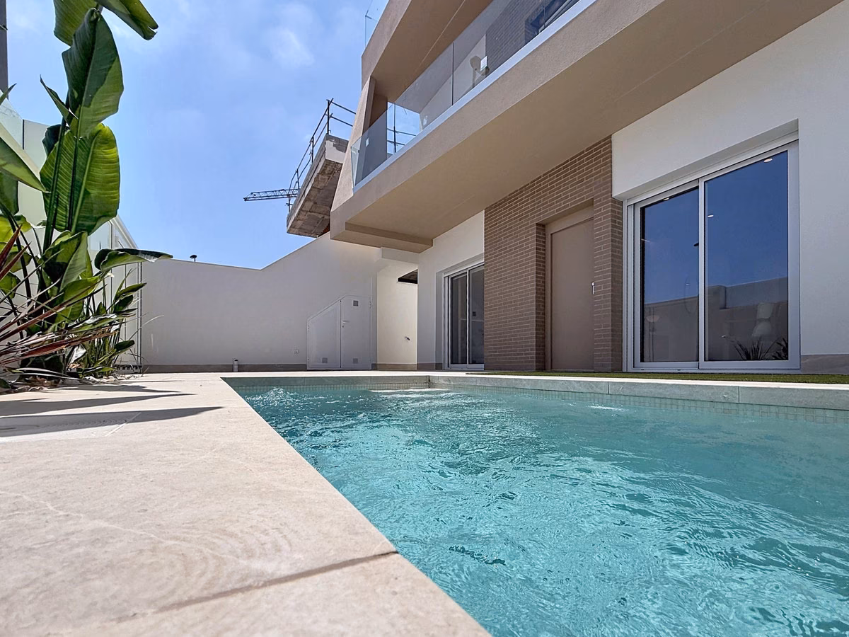 Courtyard pool with a banana plant and the upper floor’s glass balcony above
