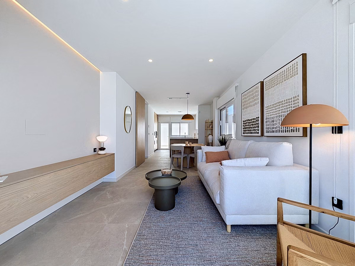 Long living room with a lit cove along the wall and a white sofa