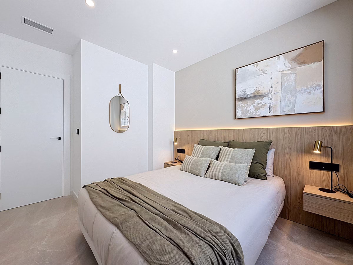 Bedroom with wooden headboard panel and wall lamps