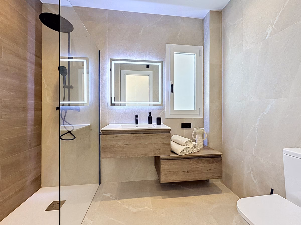 Bathroom with walk-in shower and backlit mirror
