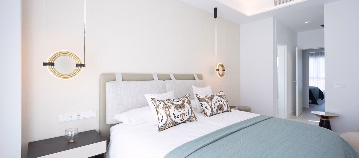 Schlafzimmer mit Pendelleuchten und weißer Bettwäsche in Santa Clara Homes