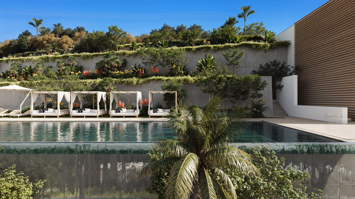 Long communal pool with sun loungers and gardens at Serenity Hills