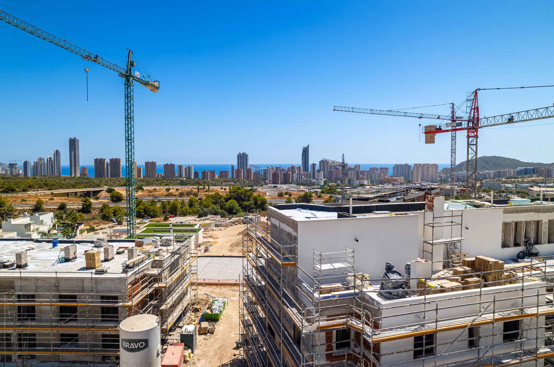 Construction, October 2026: apartment blocks rising, with the Benidorm skyline behind