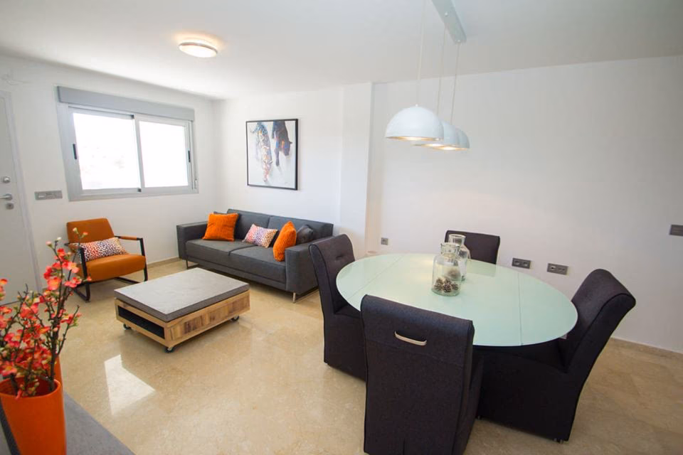 Living room with grey sofa and round dining table