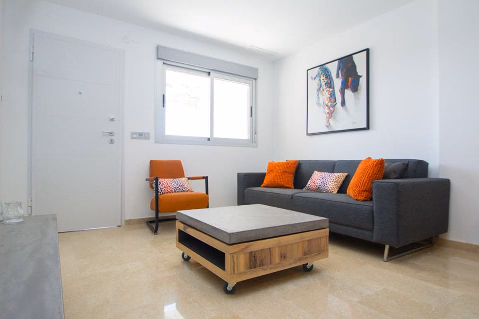 Living room with sofa, orange armchair and coffee table