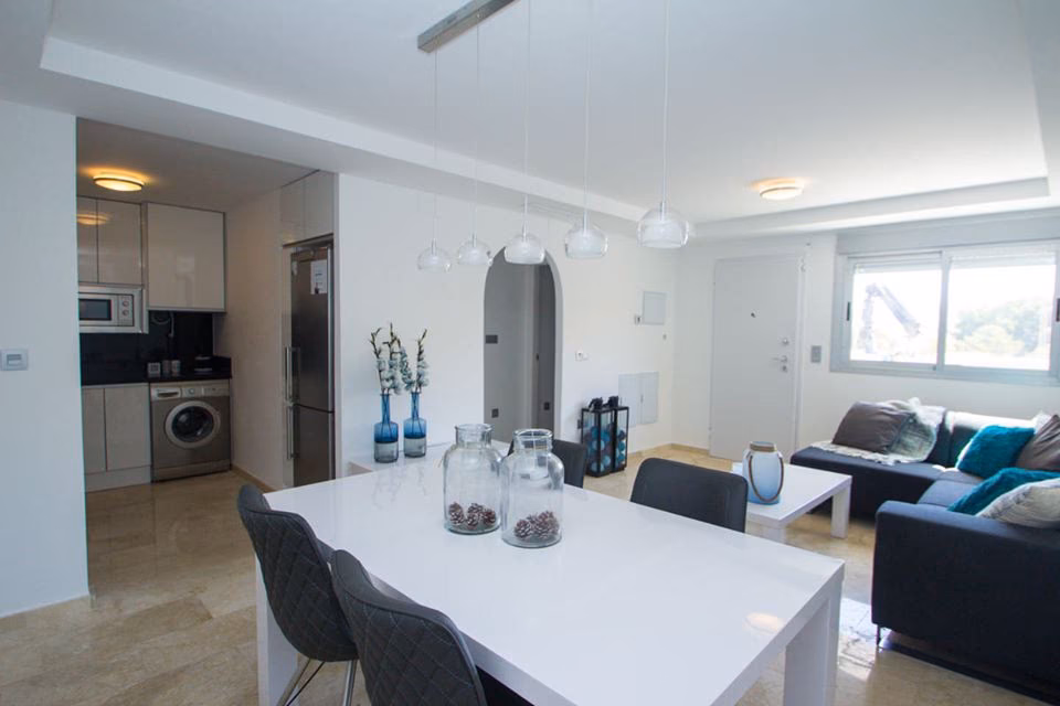 Dining table with the kitchen and living area beyond