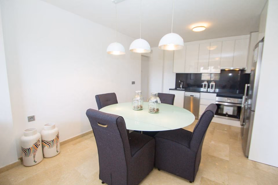 Round dining table beside the white fitted kitchen