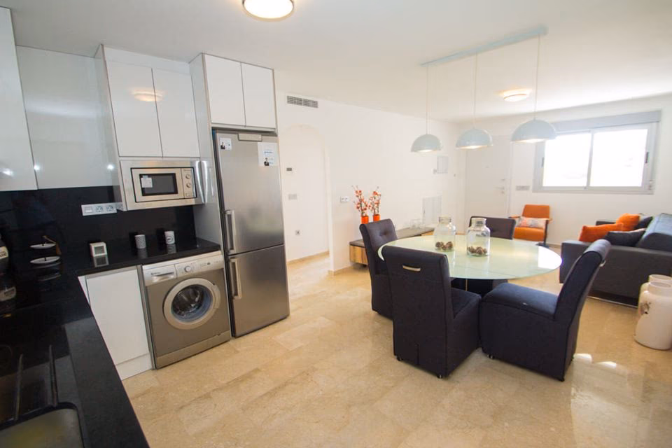 Fitted kitchen with appliances next to the dining area