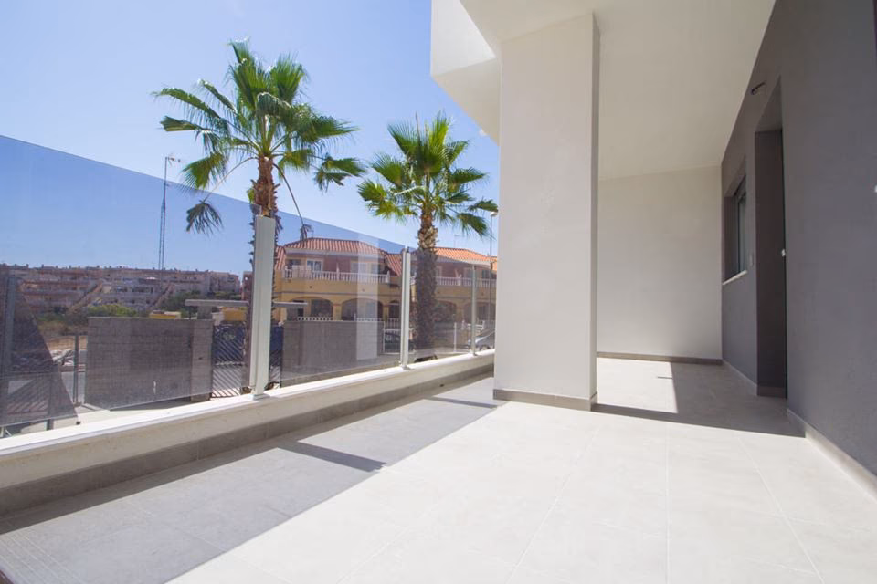 Terrace with glass balustrade and palm trees beyond