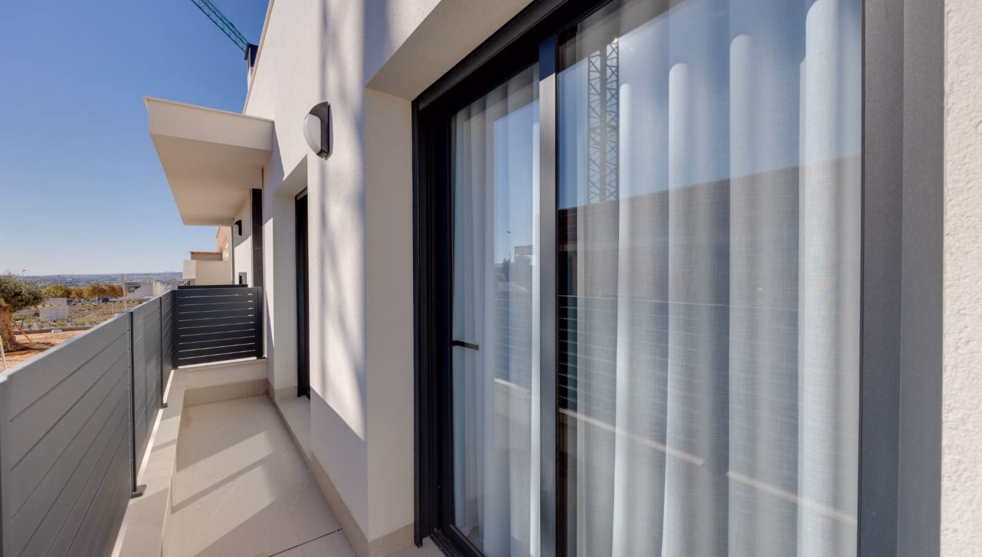 Seitliche Terrasse mit gläsernen Schiebetüren