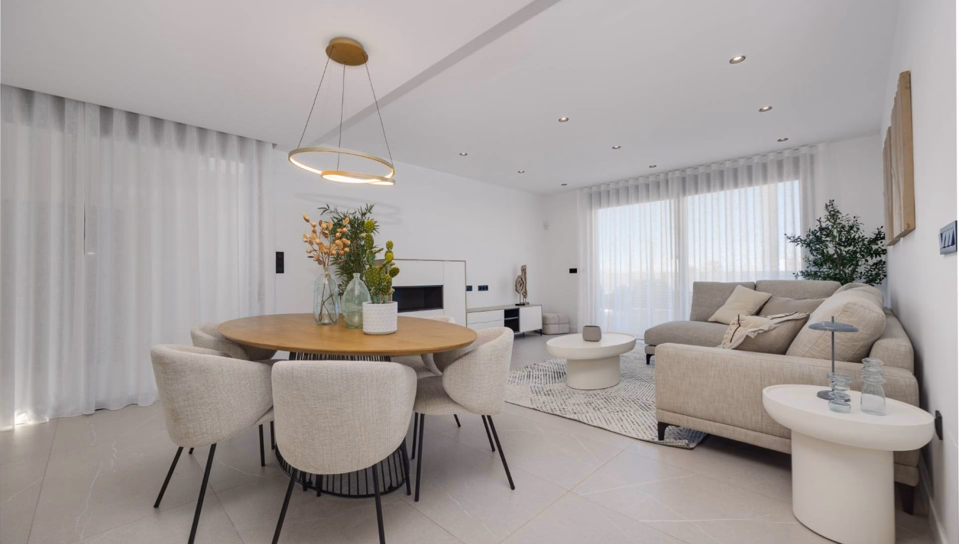 Essbereich mit rundem Tisch, dahinter das Wohnzimmer