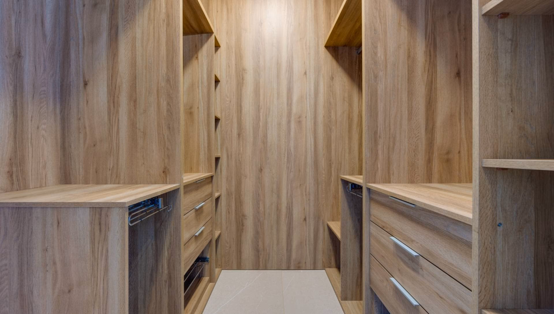 Begehbarer Kleiderschrank mit Regalen und Schubladen in Holzoptik