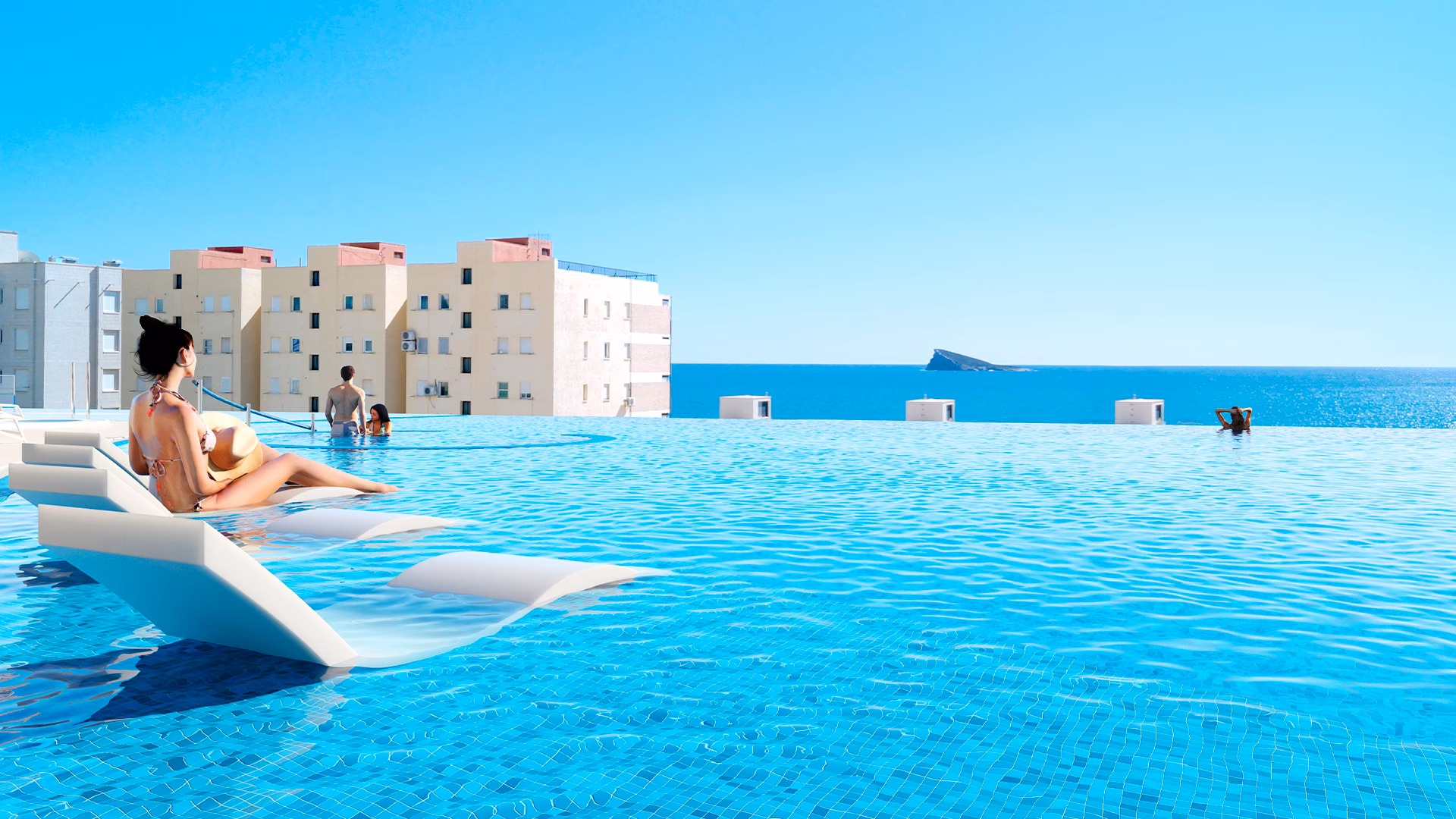 Infinity pool edge with in-water loungers and Benidorm island on the horizon