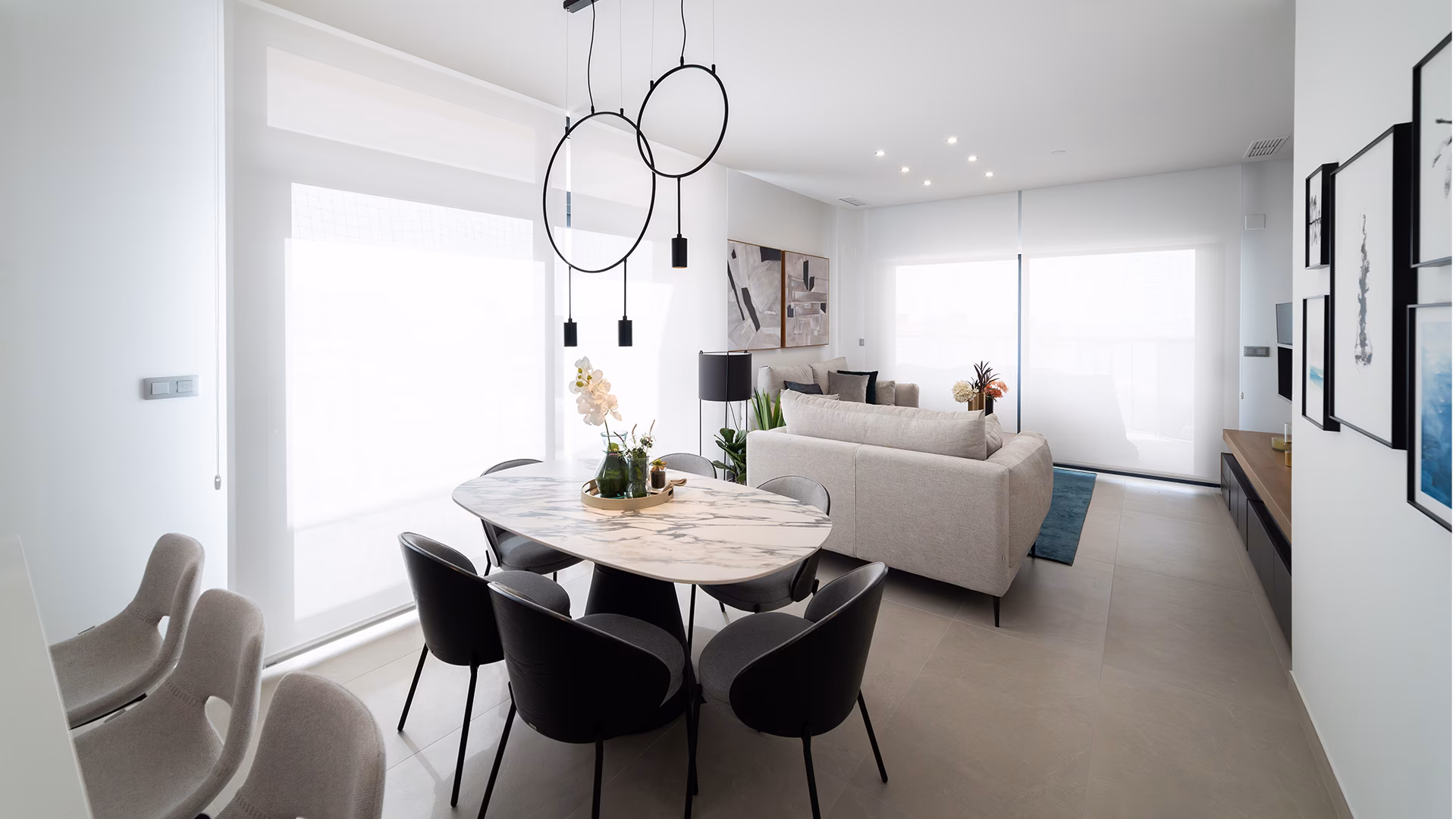 Living and dining area with round table and ring pendant lights