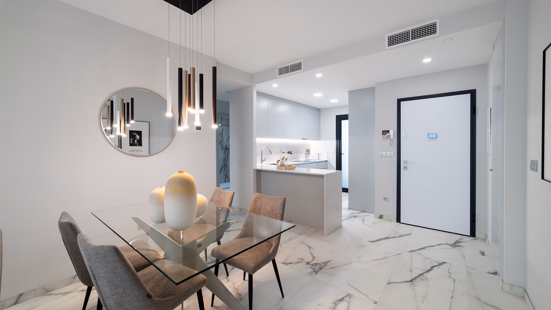 Glass dining table near the kitchen and front door