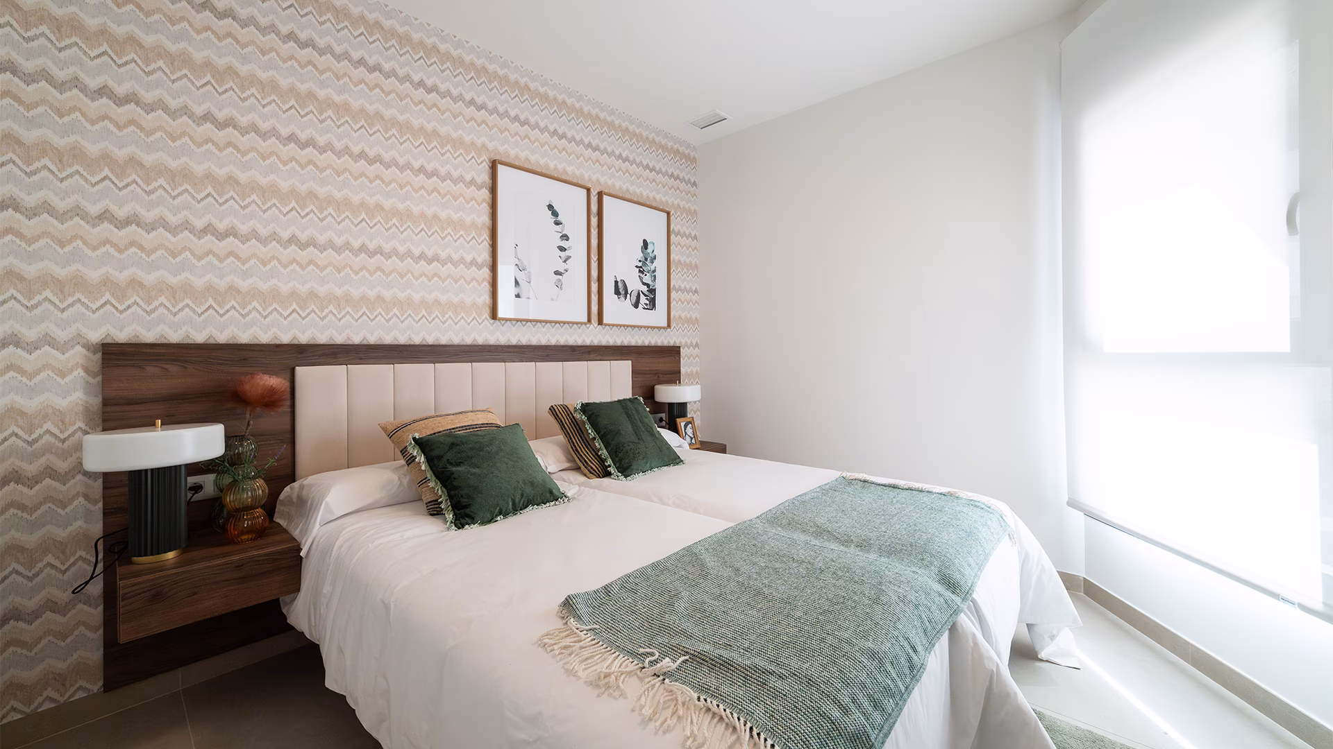 Bedroom with patterned wallpaper and green bedspread