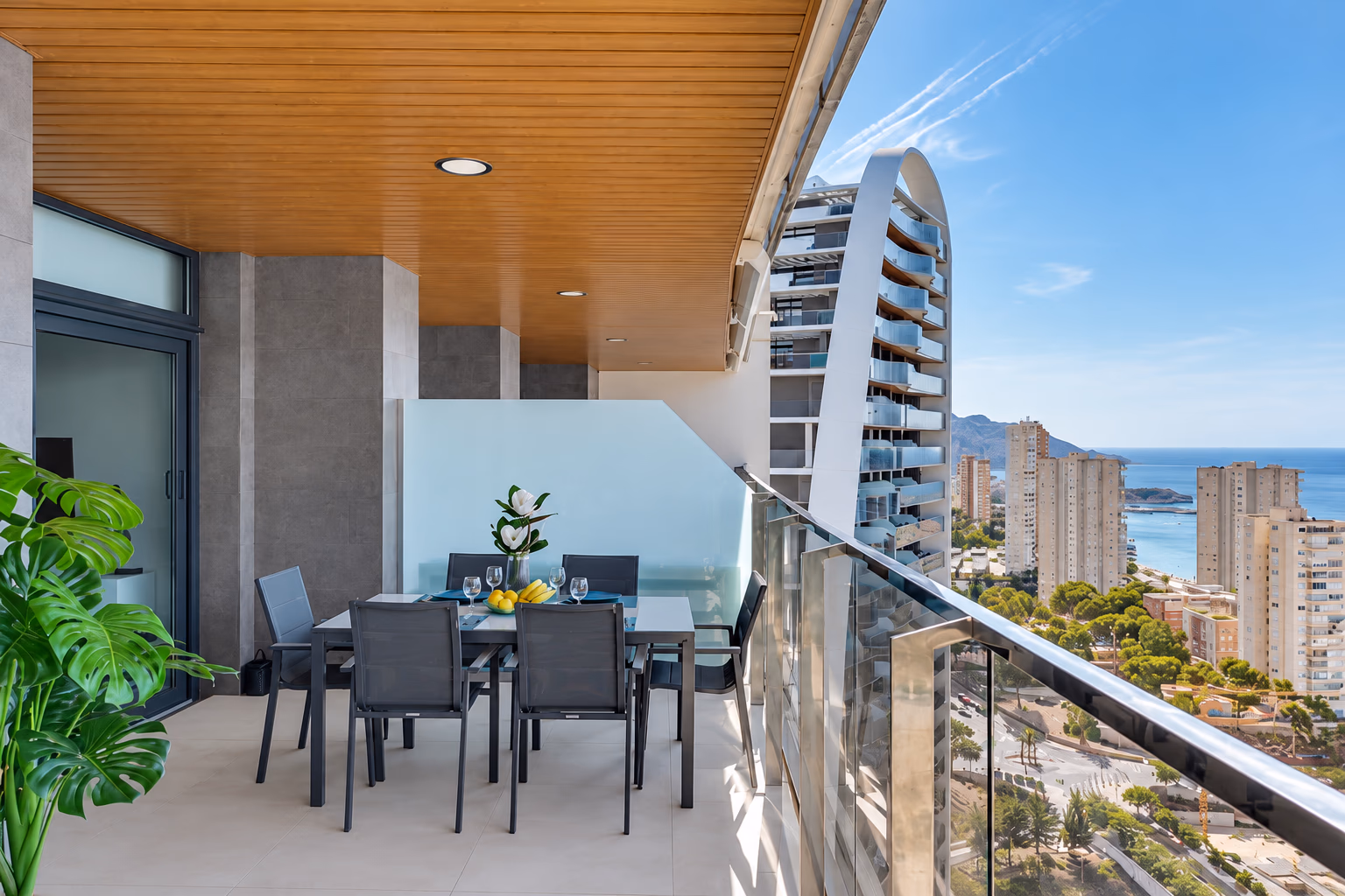 Terrasse mit Esstisch und Blick entlang der Küste von Poniente und auf die Hügel