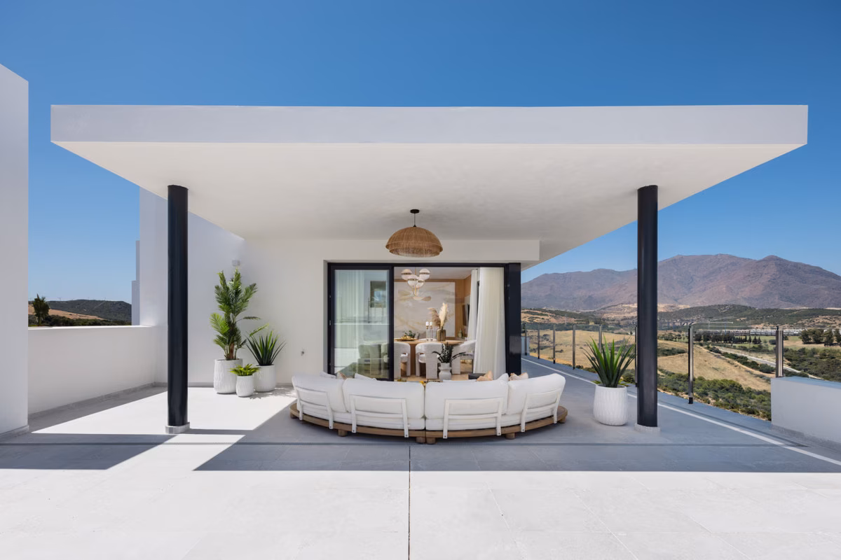 Covered roof terrace with curved outdoor sofa and mountain view