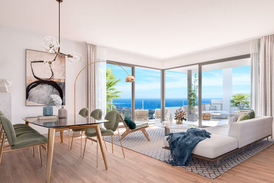 Dining area and sofa beside a corner window onto the sea