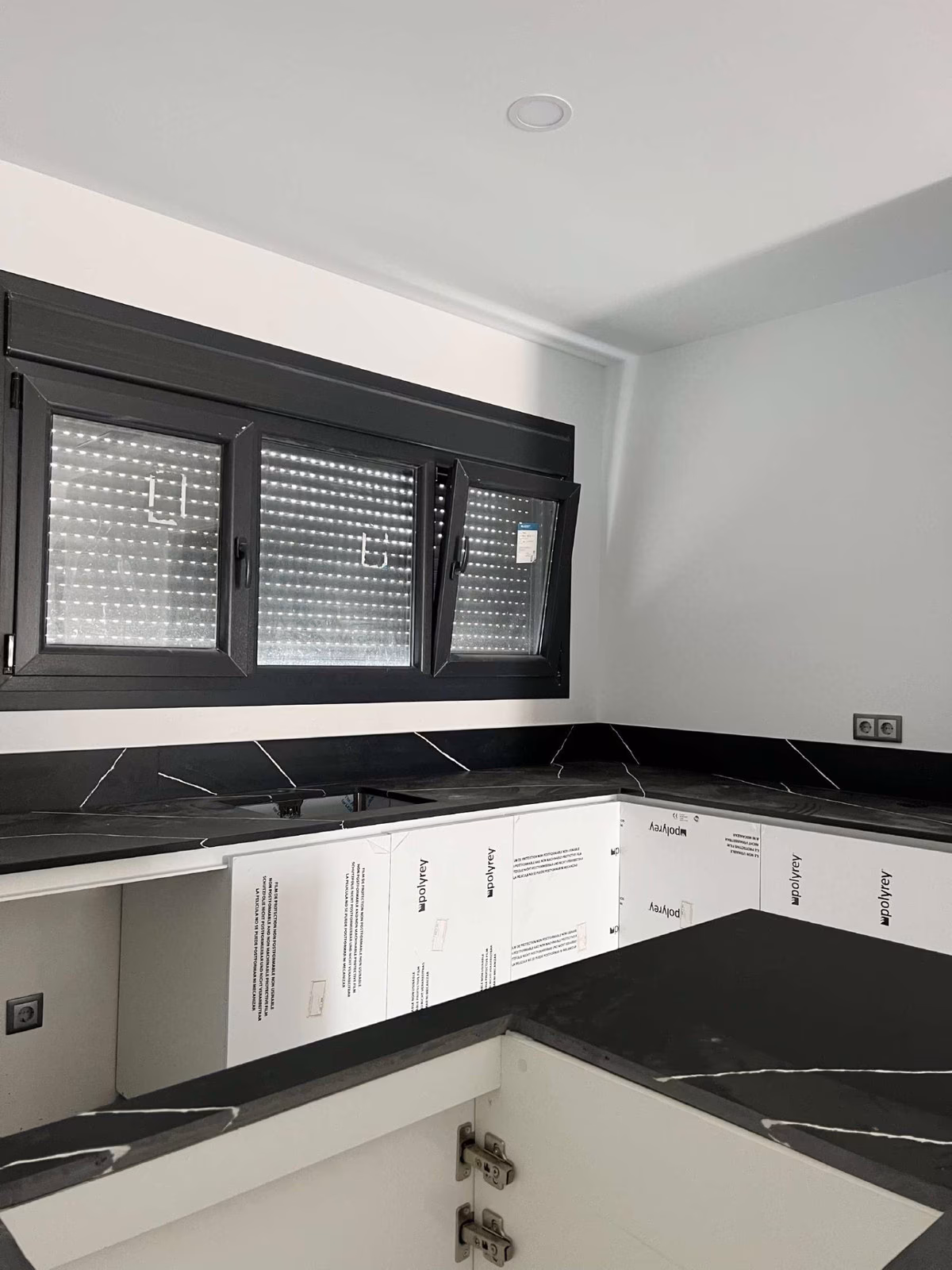 Kitchen corner with black stone-effect worktop during installation