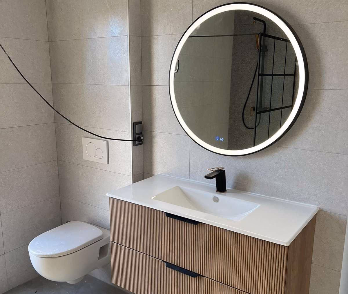 Bathroom with timber vanity and round illuminated mirror