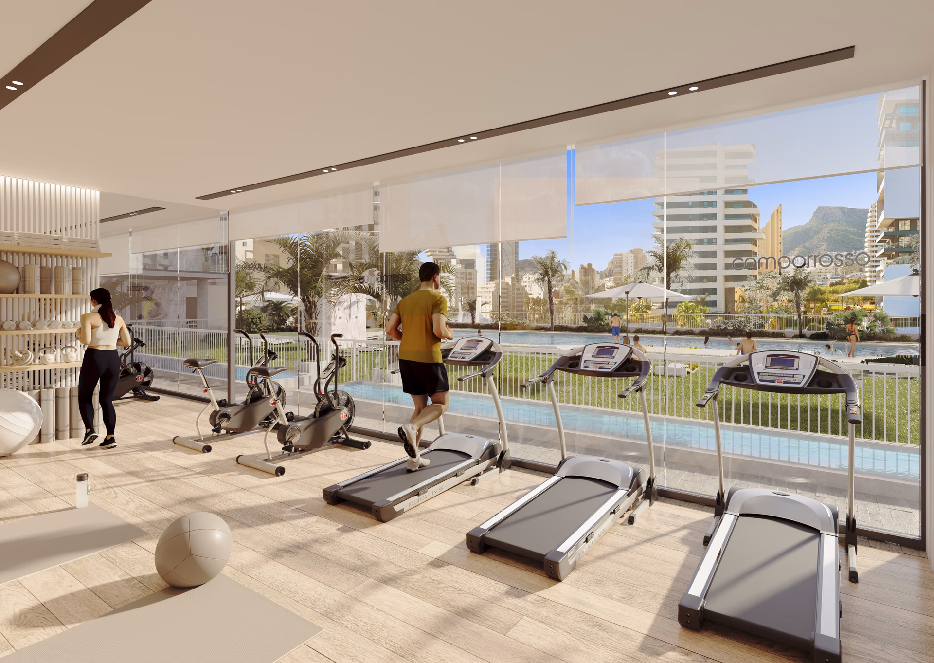 Salle de sport avec tapis de course et vélos d’appartement face à la piscine