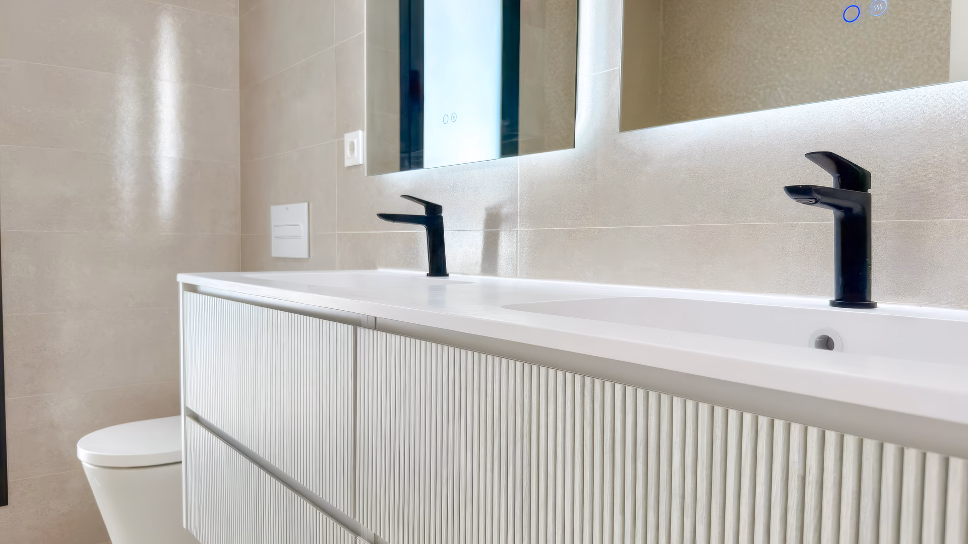 Badezimmer mit Doppelwaschtisch und schwarzen Armaturen