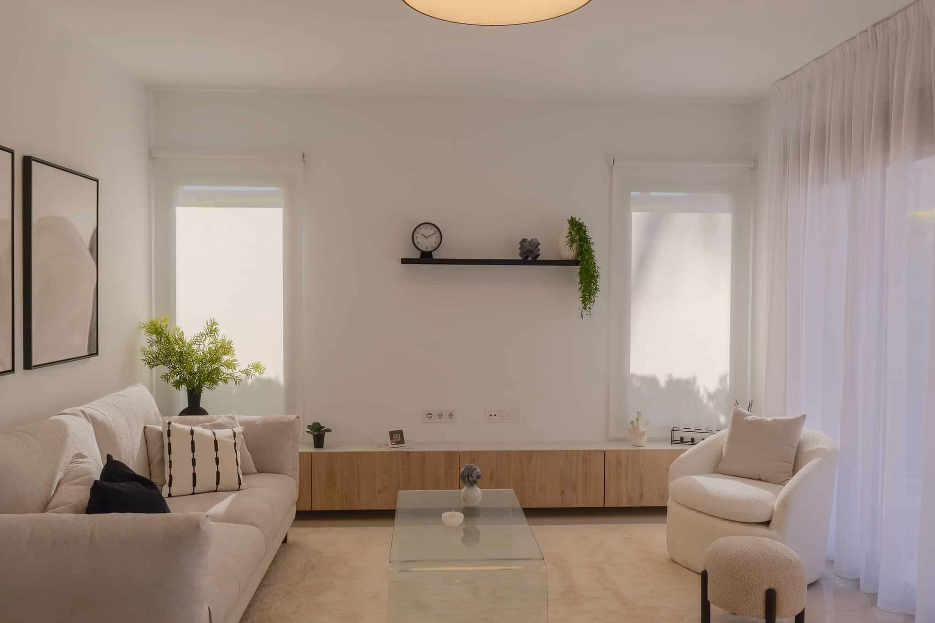 Wohnzimmer mit Sofa, Sessel und Glascouchtisch
