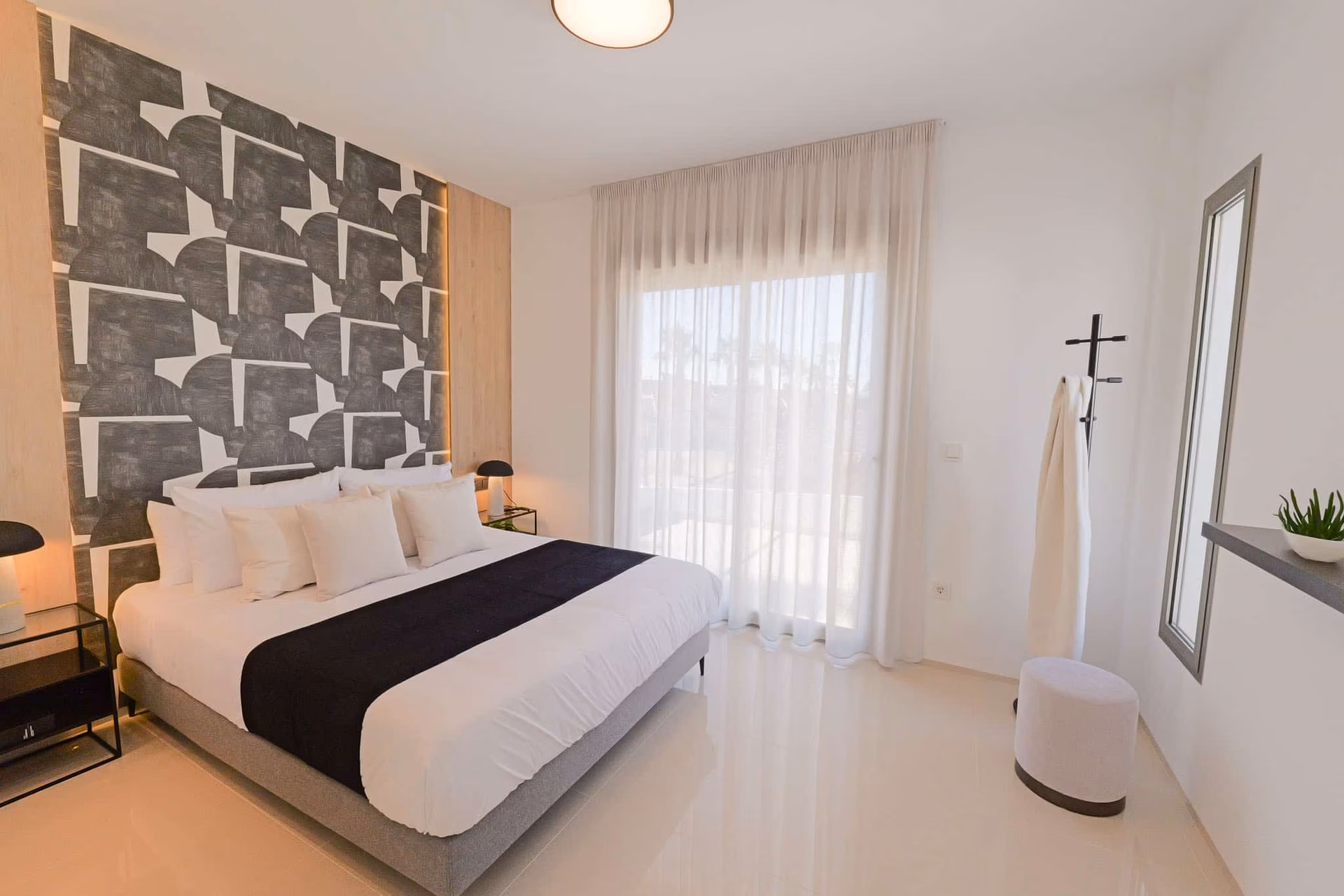 Schlafzimmer mit Doppelbett und Schiebefenster zur Terrasse