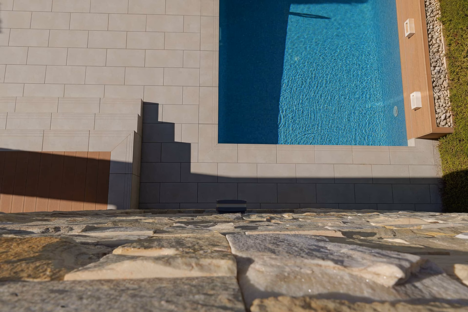 Poolrand und Natursteinmauer der Terrasse