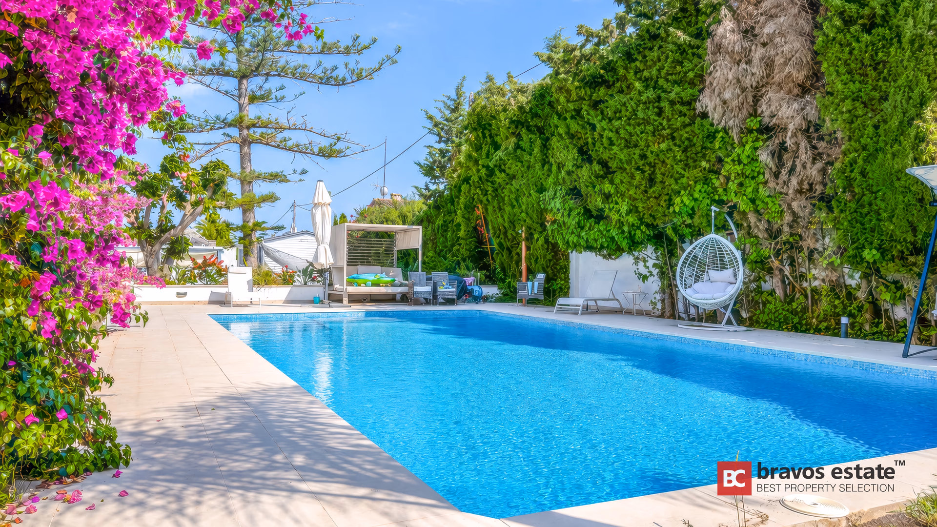 Terraza de la piscina con sillas colgantes y jardín mediterráneo de porte