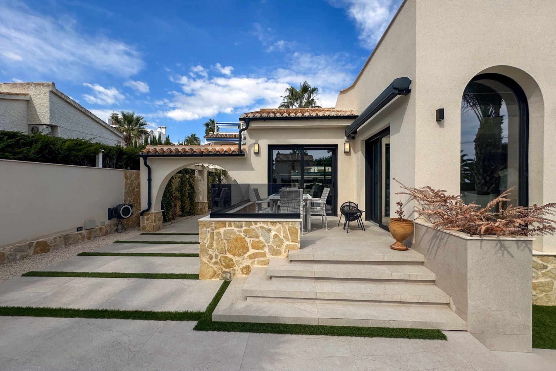 Paved courtyard with planters in front of the villa entrance