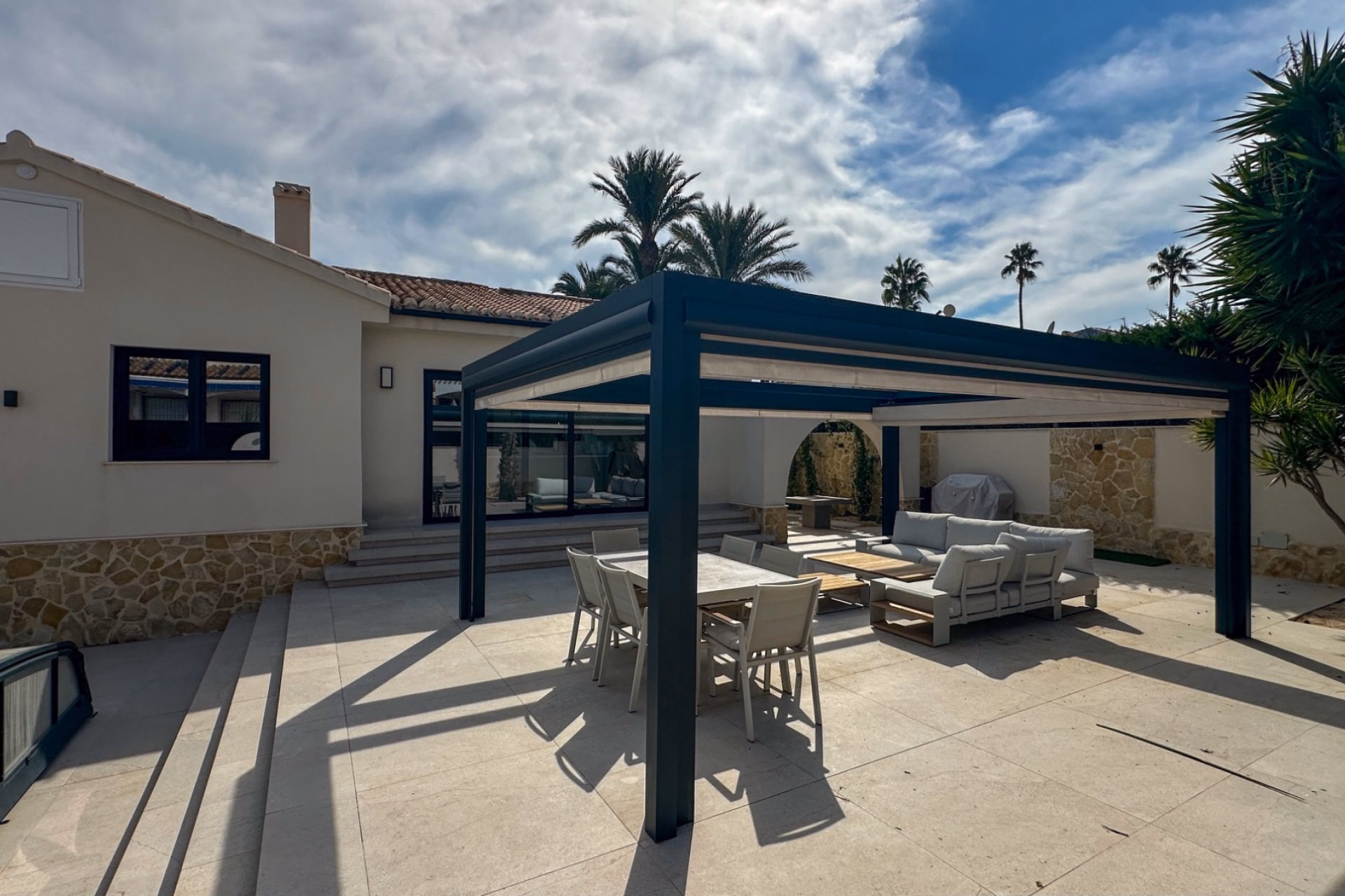 Pergola-covered dining area on the terrace in front of the house