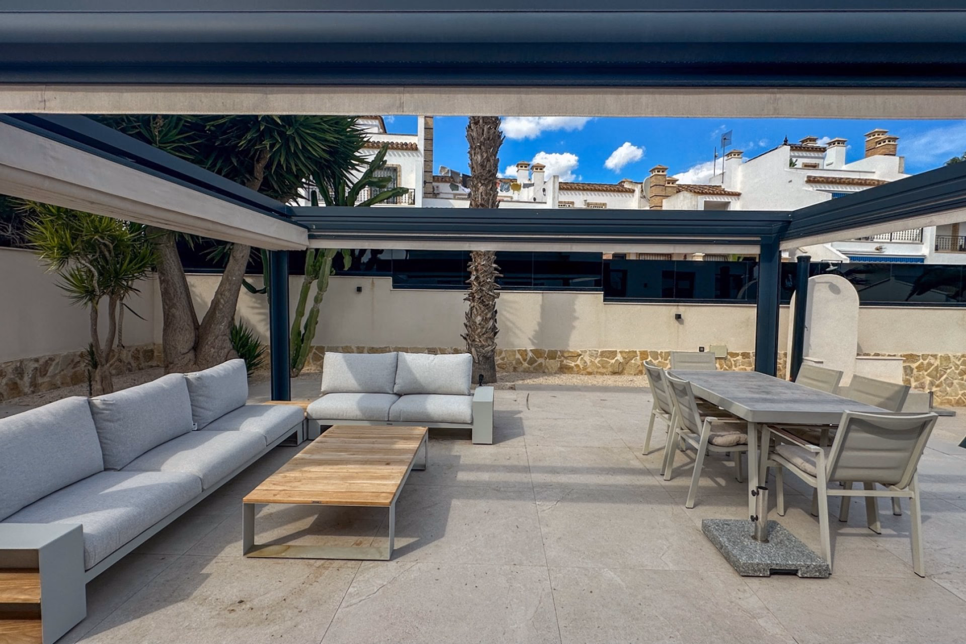 Outdoor lounge and dining sets under the pergola on the main terrace