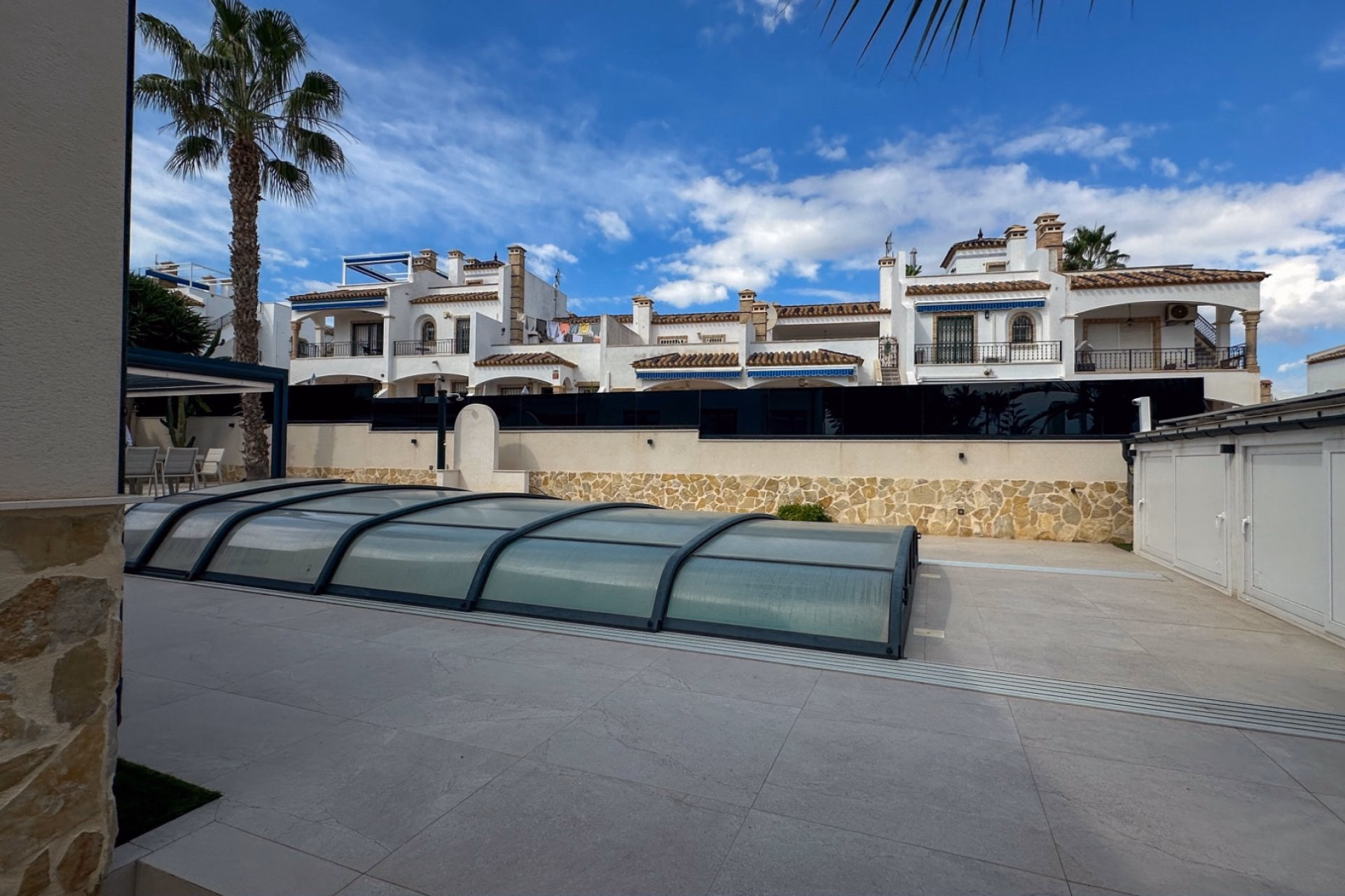 Private pool beside the paved terrace and the boundary wall