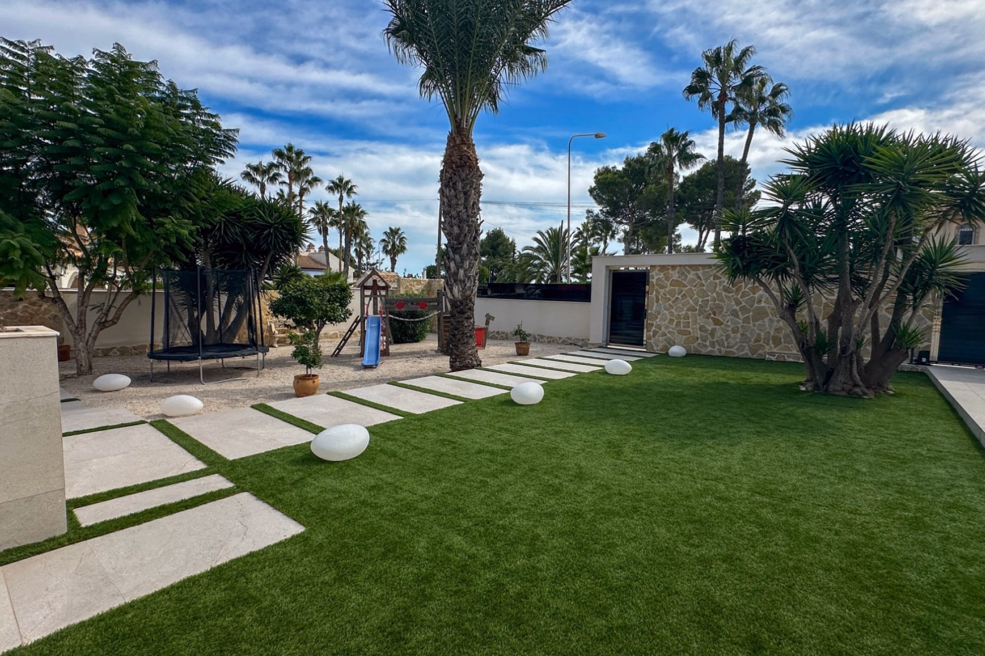 Garden with stepping-stone path, palms and white garden lights