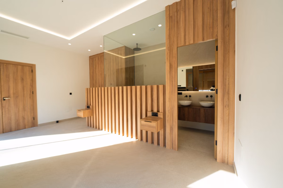 Hauptschlafzimmer mit dem En-suite-Bad hinter Glas