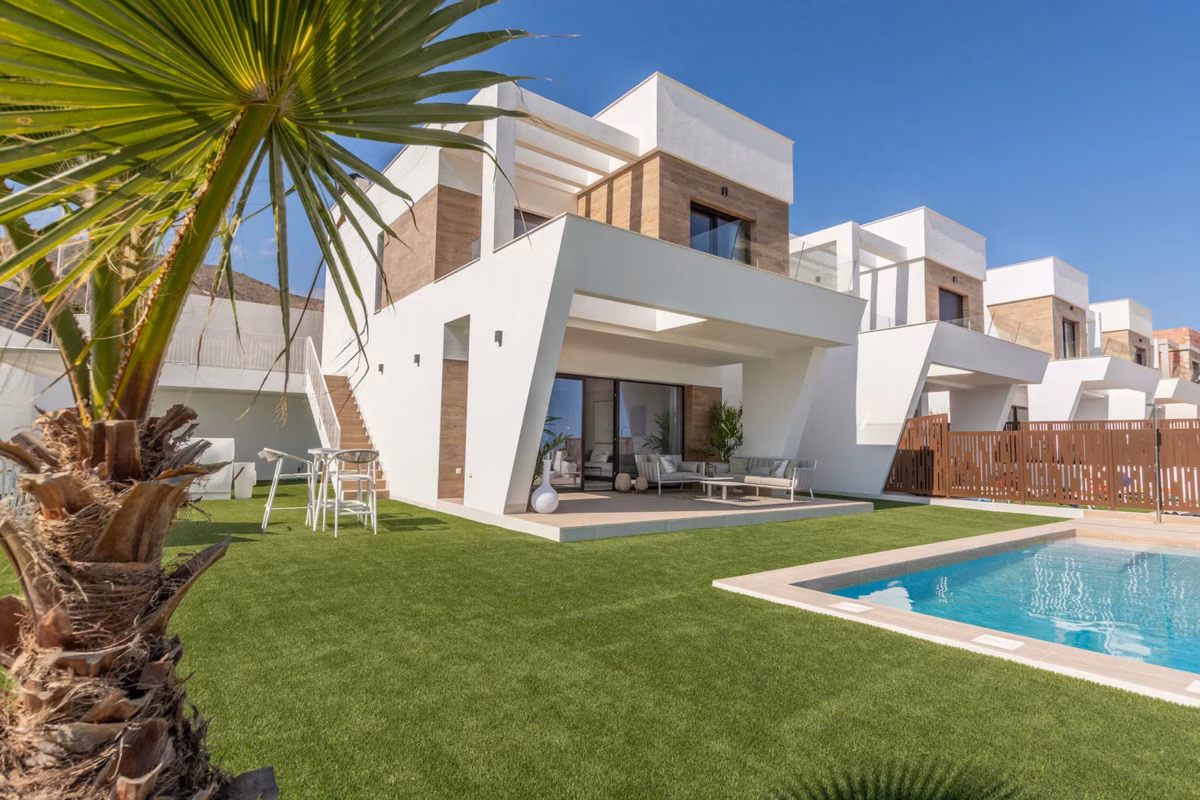 Front of the villa with the lawn and pool, neighbouring villas behind