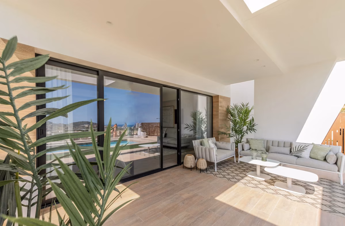 Living room with sliding doors open to the pool terrace