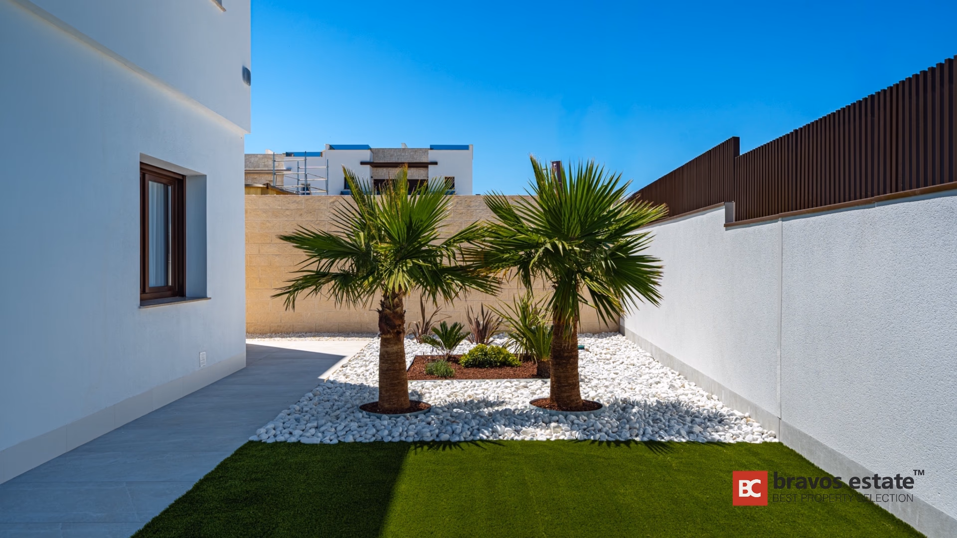 Jardin privé avec palmiers et massifs de galets blancs à Villa Valencia