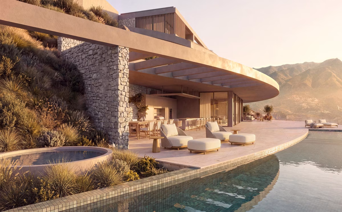 Infinitypool naast een natuurstenen muur, loungeterras en bergzicht bij zonsondergang