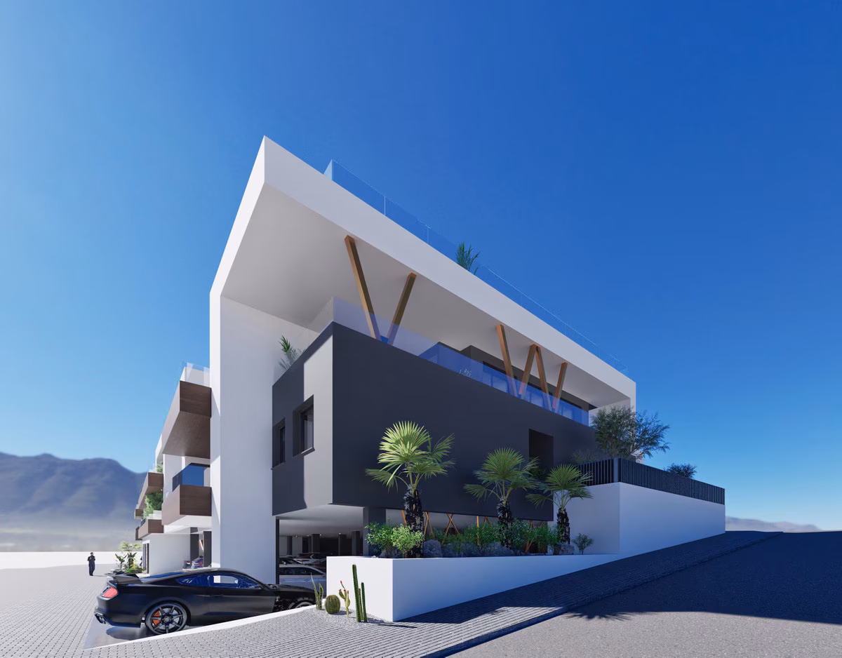 Corner of the building with rooftop terraces and palm trees, mountains behind, Benijófar