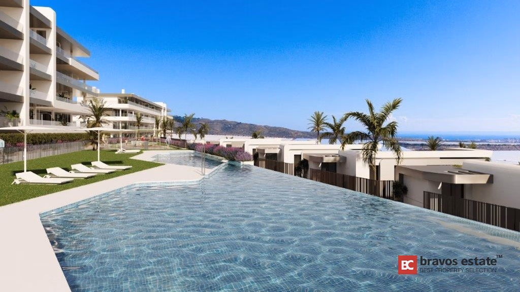 CGI render of the communal infinity pool at Bonalba Green Villas, with sun loungers, palm trees, white villa rooftops, and a panoramic coastal view under blue skies.